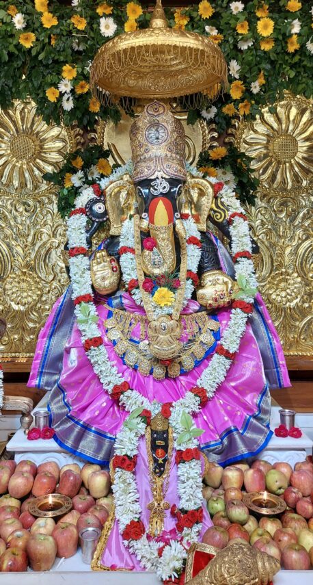 रानी रंग की पोशाक में सजे महागणपति, ओम तिलक ने बढ़ाई दिव्य आभा